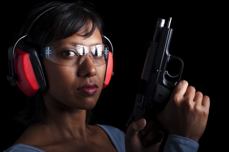 Woman practicing self-defense at gun range